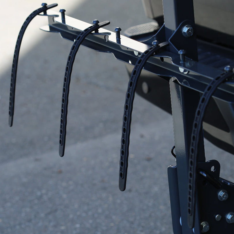 Bicycle rack attached to a vehicle with a blurred background, bungees