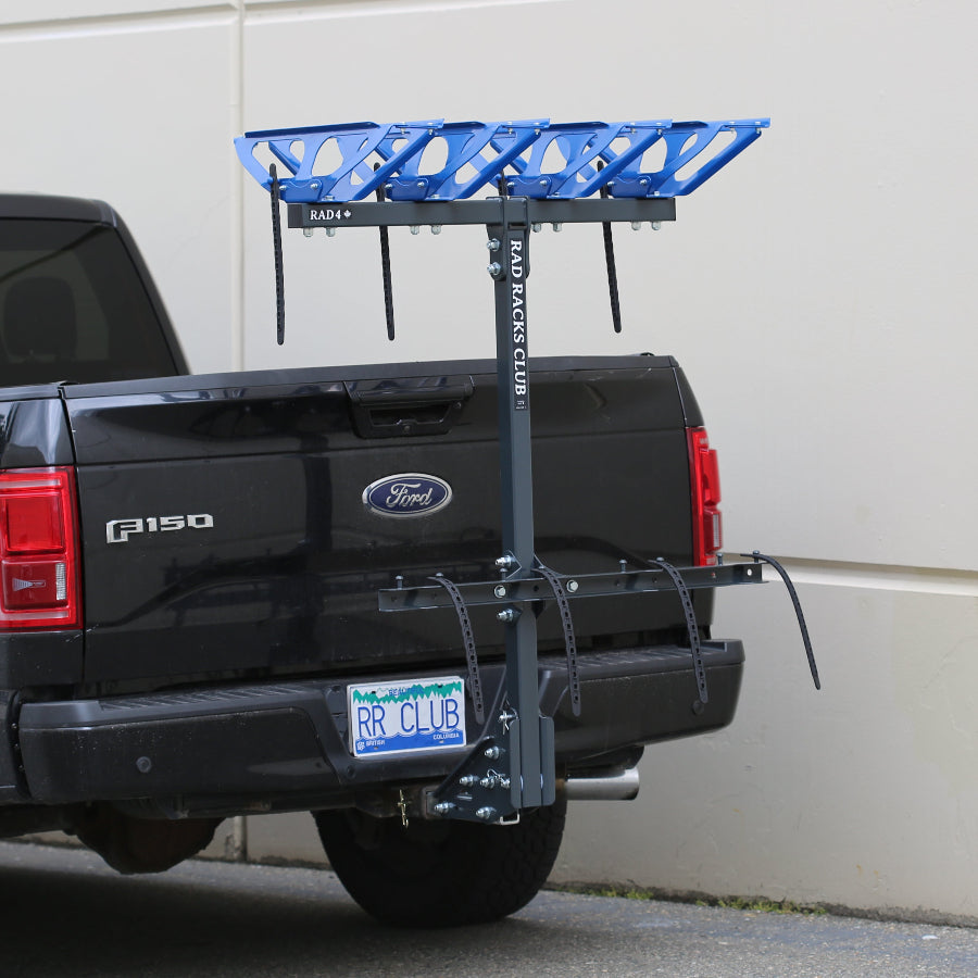 Black Ford truck with a blue bike rack attached to the back