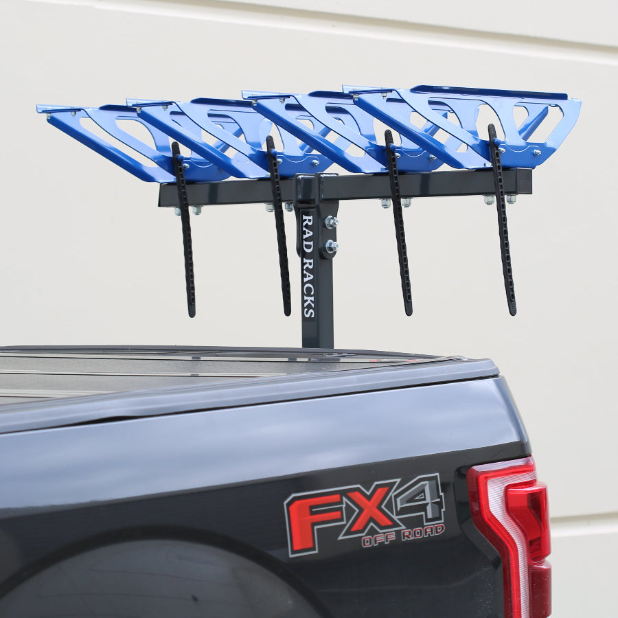 Blue bike rack on a truck bed with a white wall background