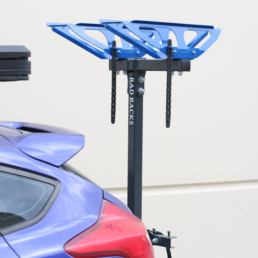 Blue bike rack attached to a car with 'RackRacks' branding.