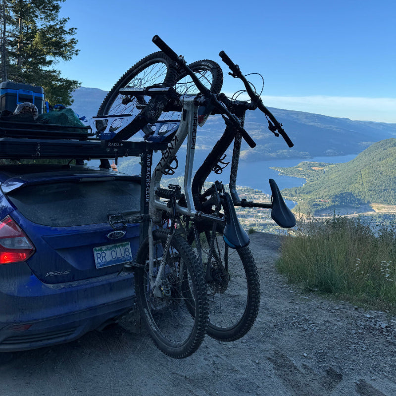 Bicycle attached to a vehicle with a scenic mountain background
