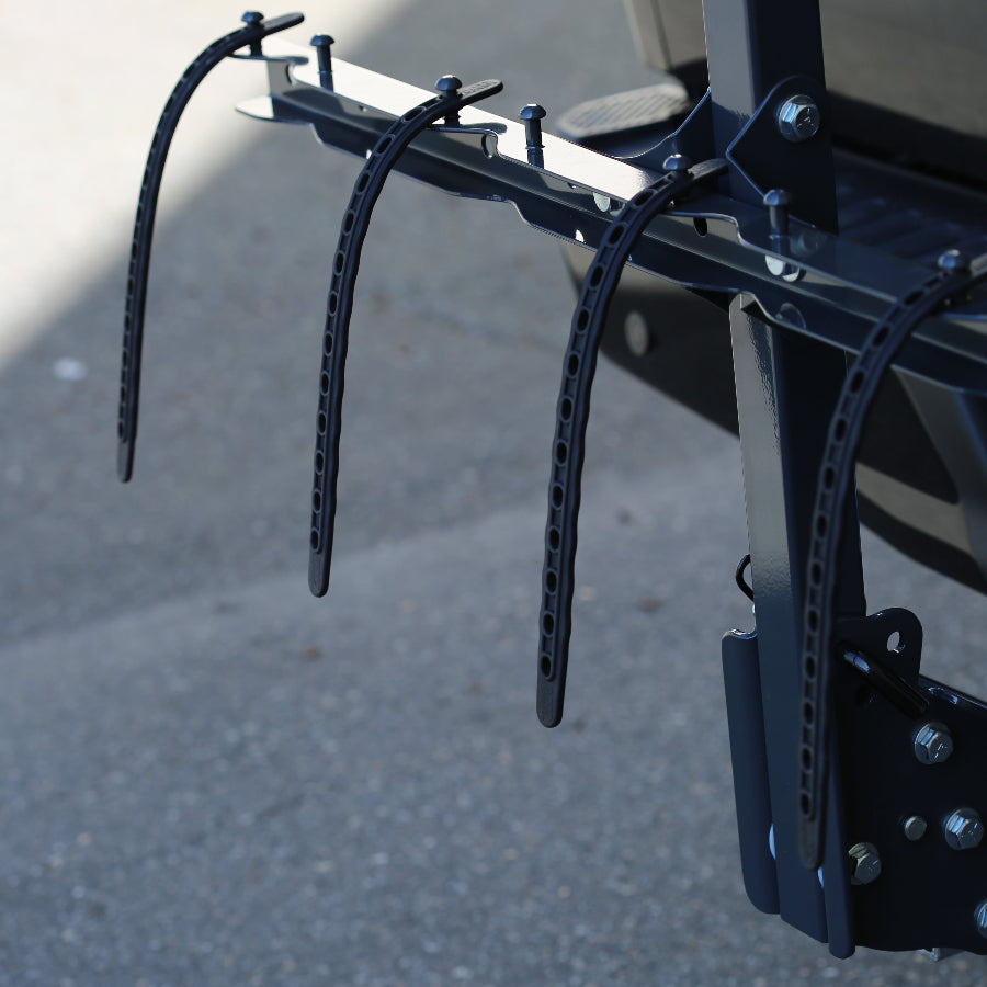 Bicycle rack attached to a vehicle with a blurred background, bungees