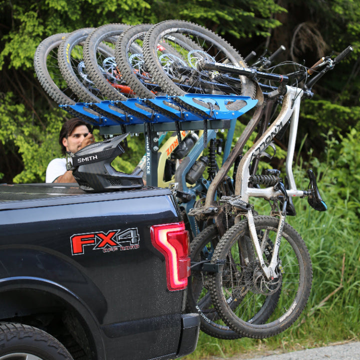 Bicycles loaded onto a truck with in forest with mountain bike racks, 5 bike rack RAD by RAD RACKS and smith optics goggles on helmet