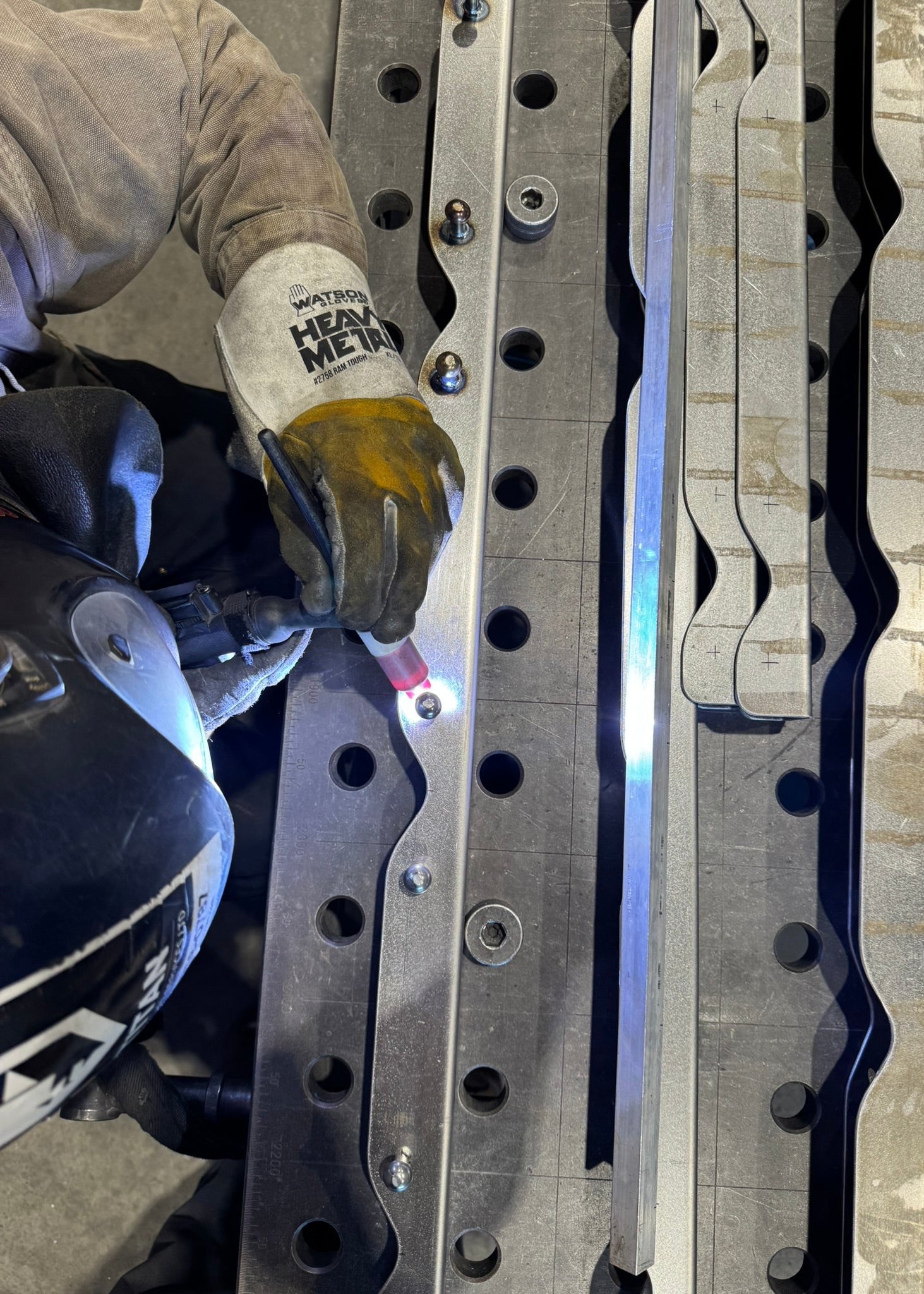 Person working on metal components with a focus on hands and tools