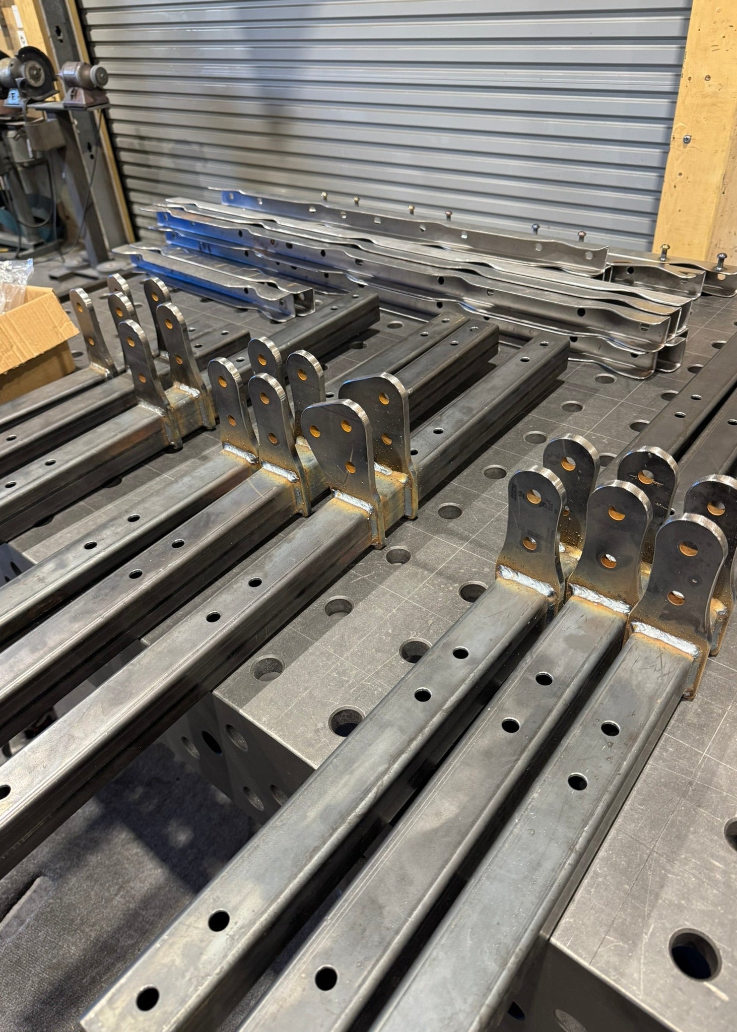 Metal brackets and components on a workbench in a workshop setting