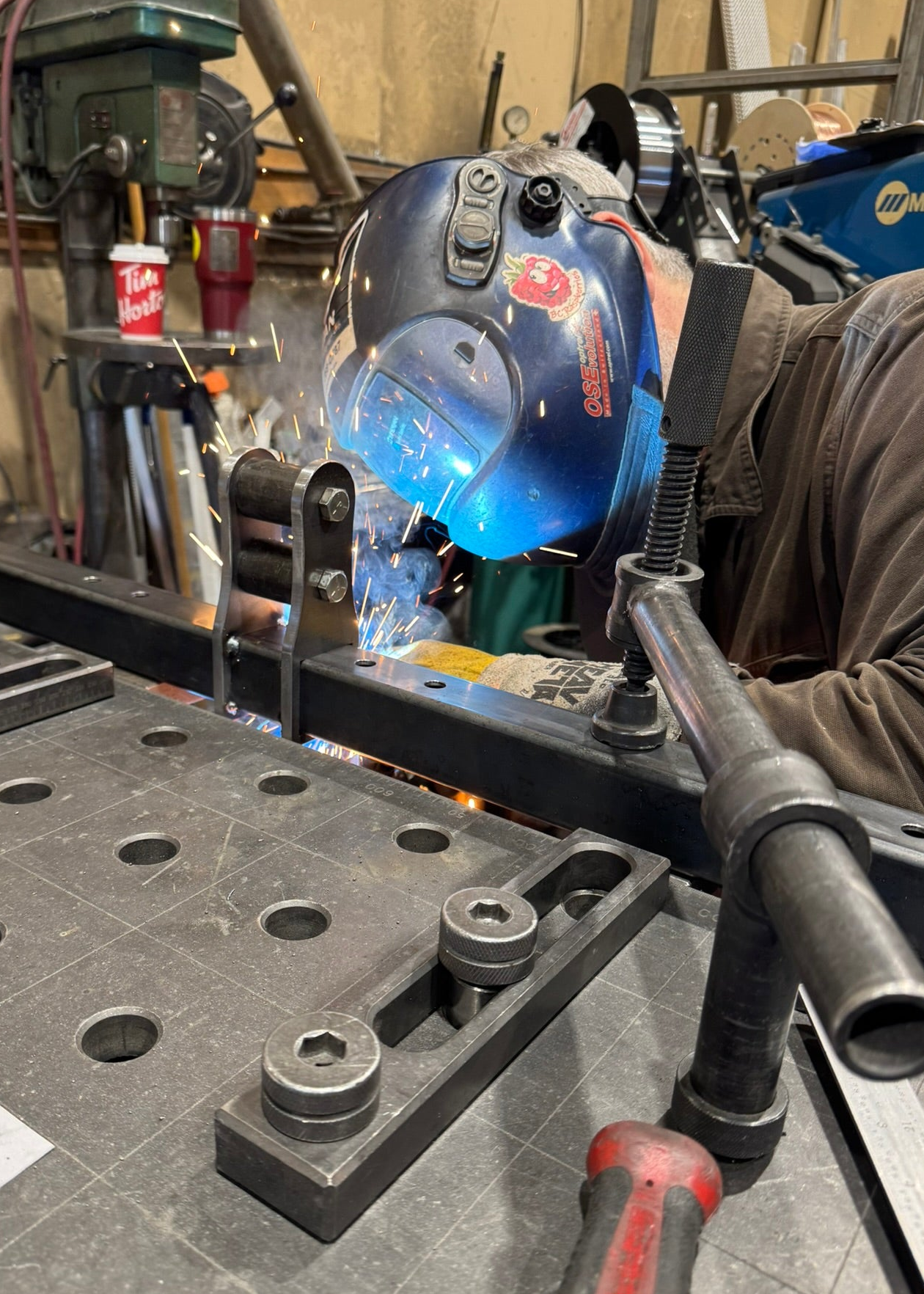 Person using tig welding in a workshop setting