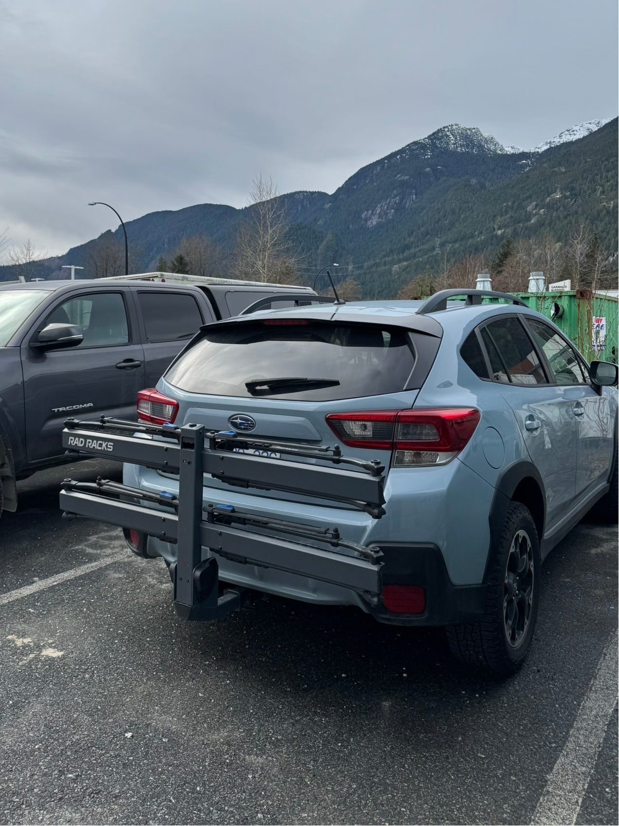 Car with a bike rack in a parking lot with mountains in the background