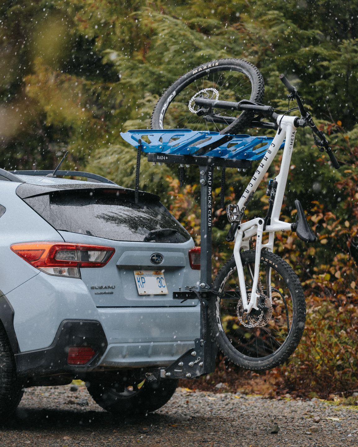 Bicycle mounted on a suv vertical bike rack with a blurred natural background in rain