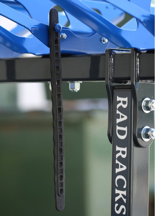 Blue car roof rack system with 'RAD RACKS' branding on a blurred background